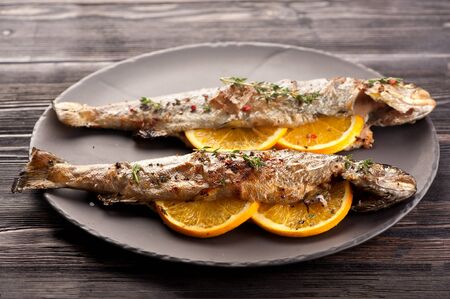 Baked trout fish with orange and thymeの写真素材
