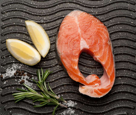 raw salmon steak with herbs and spices