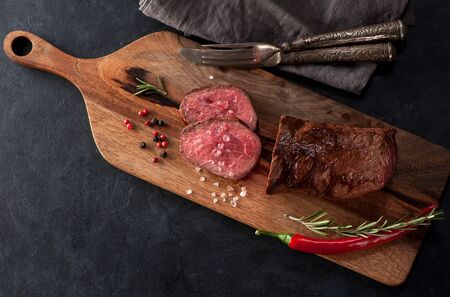 Roast beef on a wooden board top view