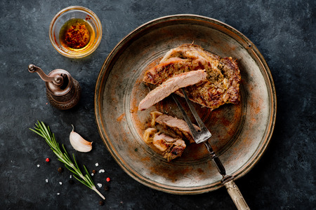 Steak Ribeye Well Done on a metal plate and fork for meatの写真素材