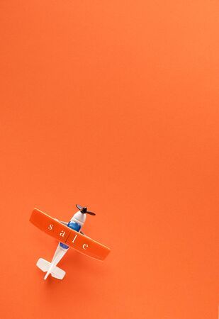 Miniature airplane with the inscription sale on orange background and space for textの写真素材