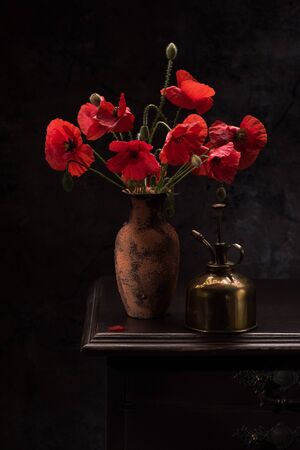 Still life with red poppies in a vase on the tableの写真素材