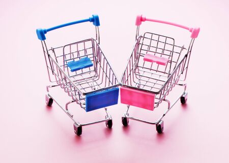 shopping trolleys on pink background with copy space