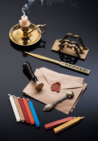 Vintage writing retro set: bronze inkwell, letter opener, old envelopes with wax seal and sealing wax for stampsの写真素材
