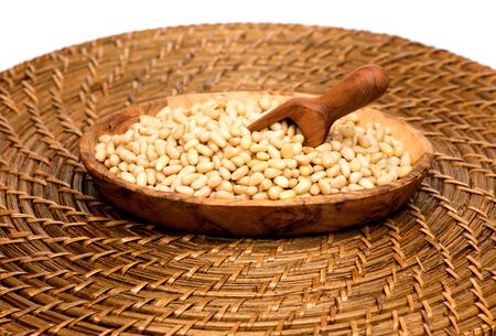 Cedar pine nuts in a bowl and a wooden scoopの写真素材