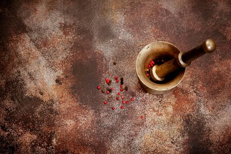 Pepper in old mortar on rusty texturesの写真素材