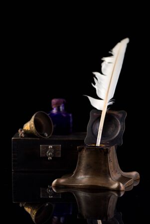 Ancient Inkwell, feather pen, old paper and a vintage bellの写真素材