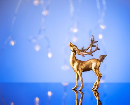 Merry Christmas and Happy New Year. Blurred lights background with a deer and garlandの写真素材
