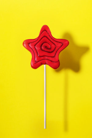 Lollipop candy on a stick on a yellow background, top view. Celebration party conceptの写真素材