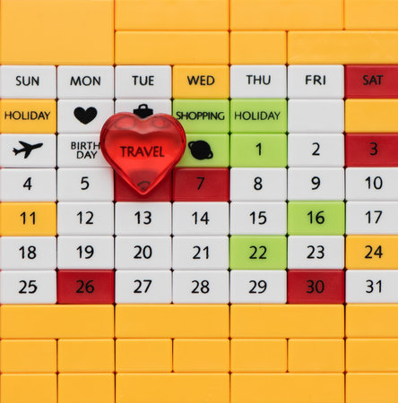 Perpetual calendar background with inscription travel and red heart, top view, close-up. Planning, vacation and travel conceptの写真素材