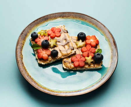 Delicious diet breakfast cereal sandwiches with peanut butter, honey and fresh fruits and berries on...