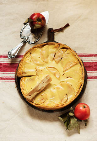 Apple pie on a wooden chalkboard on a textile napkin, top viewの写真素材