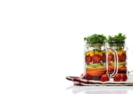 Healthy homemade salad with fresh vegetables and sprouts in glass jars on a white background. Healthy food concept, diet, detox, clean food, vegetarian concept, copy spaceの写真素材