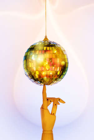 Wooden hand holding mirrored Disco ball. Minimalism party concept. Festive Christmas and New Year...