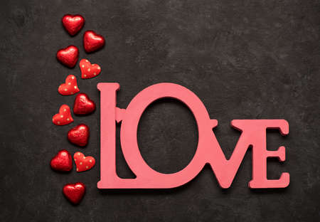 Valentine's day concept, word love and heart shaped decor and candies. Top view, flat lay, copy...