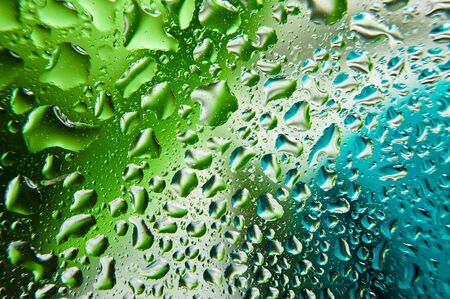 Water drops on glass with color backgroundの写真素材