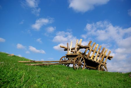 Old cart on green field. Nature composition.の写真素材