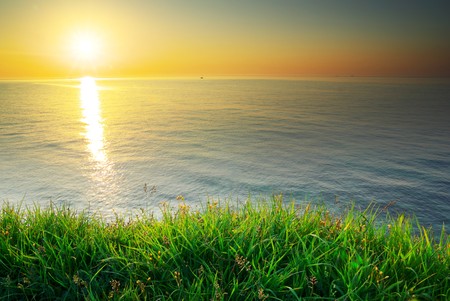Sundown composition. Sky, sea, and green grass. の写真素材