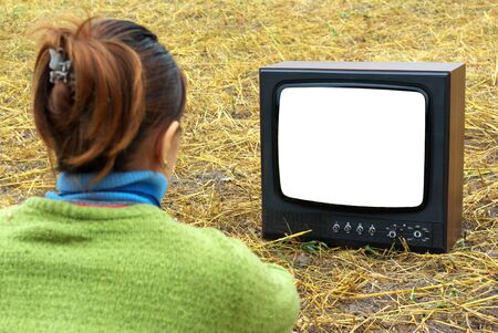 Girl watching TV in meadow. Element of design.の写真素材