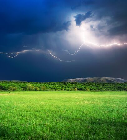 Thunderstorm with lightning  in green meadow. Nature composition.の写真素材