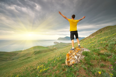 Man rising to sun. Mountain and sea nature. Conceptual design.の写真素材