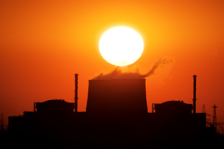 Power plant on the sunset. Big sun and energy industry.の写真素材