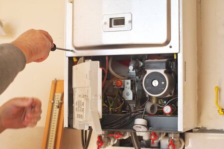 Man engineer and gas heater. Repair and work scene.の写真素材