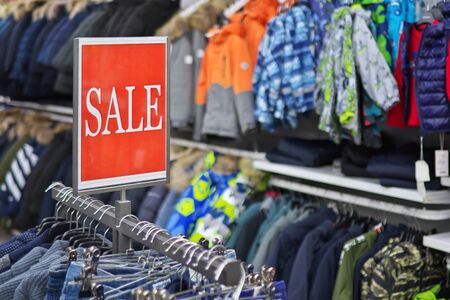 Sale sign notice into a clothes store. Shopping mall advertisement.