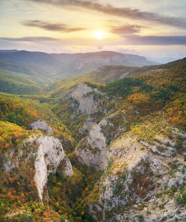 Autumn mountain view with sunshine and haze into canyon. Panorama landscape.の写真素材