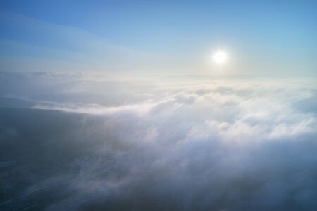 Aerial view white clouds in sky. Top cloudscape view from drone. Deep blue colours. 