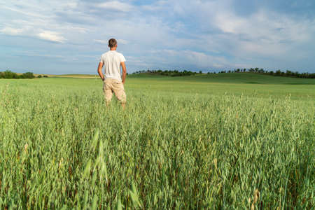 Man in meadow green meadow of oats.