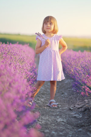 Little girl enjoy nature on meadow of lavender. Emotional and conceptual scene.の写真素材