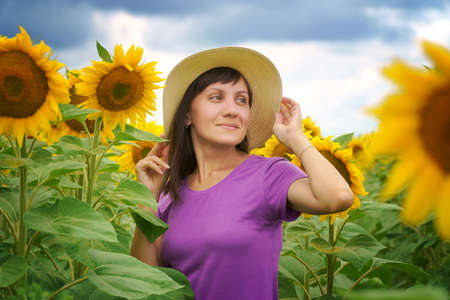 Woman in sunflower field at day. Nature and people.の写真素材