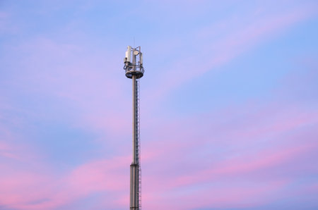 Cell phone tower during the sunset. Telecommunication scene.