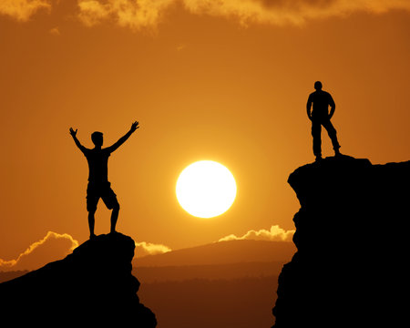 Man on top of mountain during big sun. Silhouette of person in nature.の写真素材