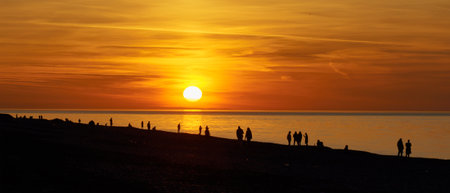 People on the seashore during the sunset. Town and nature life scene.の写真素材