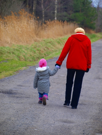 grandmother with granddaughter walk village street in the early springの写真素材