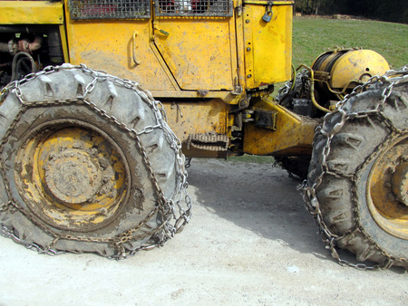 Closeup of wheels of the tractor chain forest in the mountainsの写真素材