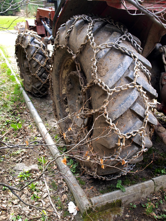 Closeup of wheels of the tractor chain forest in the mountainsの写真素材