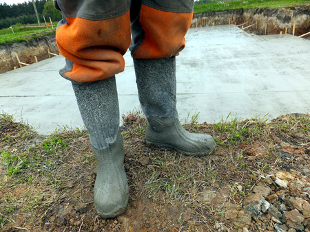 Rubber boots soiled cement during concretingの写真素材