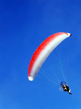 Para glider flying along the coast at the serene sky
