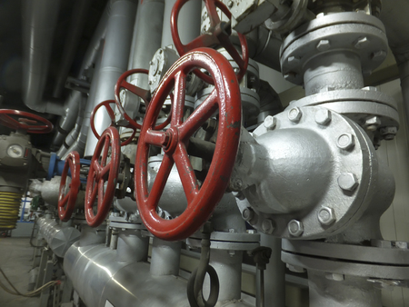 Pipes and valves with red knobs for hot waterの写真素材