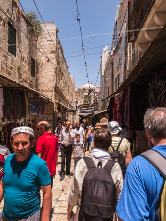 Jerusalem, Israel - July 15, 2015:  Narrow stone street among stalls with traditional souvenirs and goods at bazaar in Old City and children at play - popular place among tourists and pilgrims visiting Jerusalem.のeditorial素材