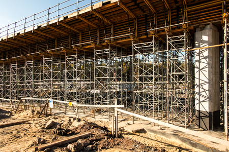 construction scaffolding built under an overpass over the highway as the background
