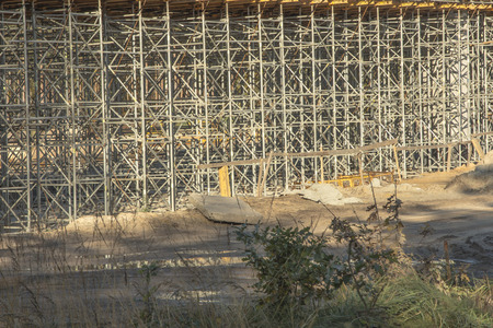 construction scaffolding built under an overpass over the highway as the background