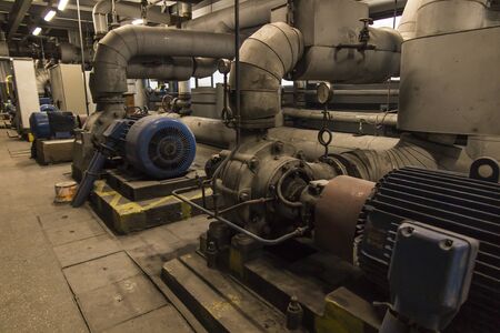 some old, dusty, pumps for hot and cold water with large electric motorsの写真素材