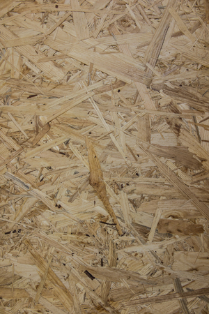 fragment of the OSB board (Oriented strand board) with visible shavings as the backgroundの写真素材