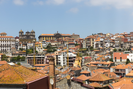 Thick buildings with a predominance of orange and brick roofs in Porto, Portugal with a visible church towerのeditorial素材