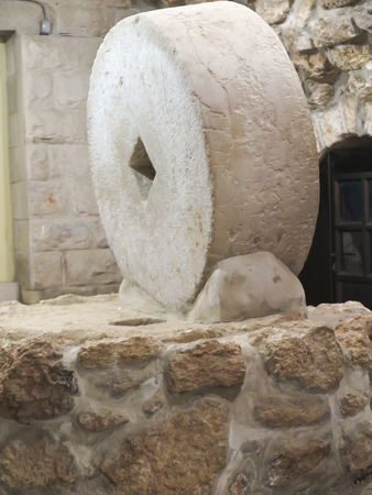 an old mill wheel as an exhibit on a stone foundationの写真素材