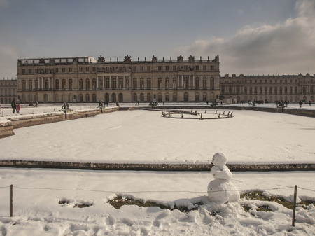 garden sculptures and pond in front of the royal residence at Versailles near Paris in France in winter scenery, the snowのeditorial素材